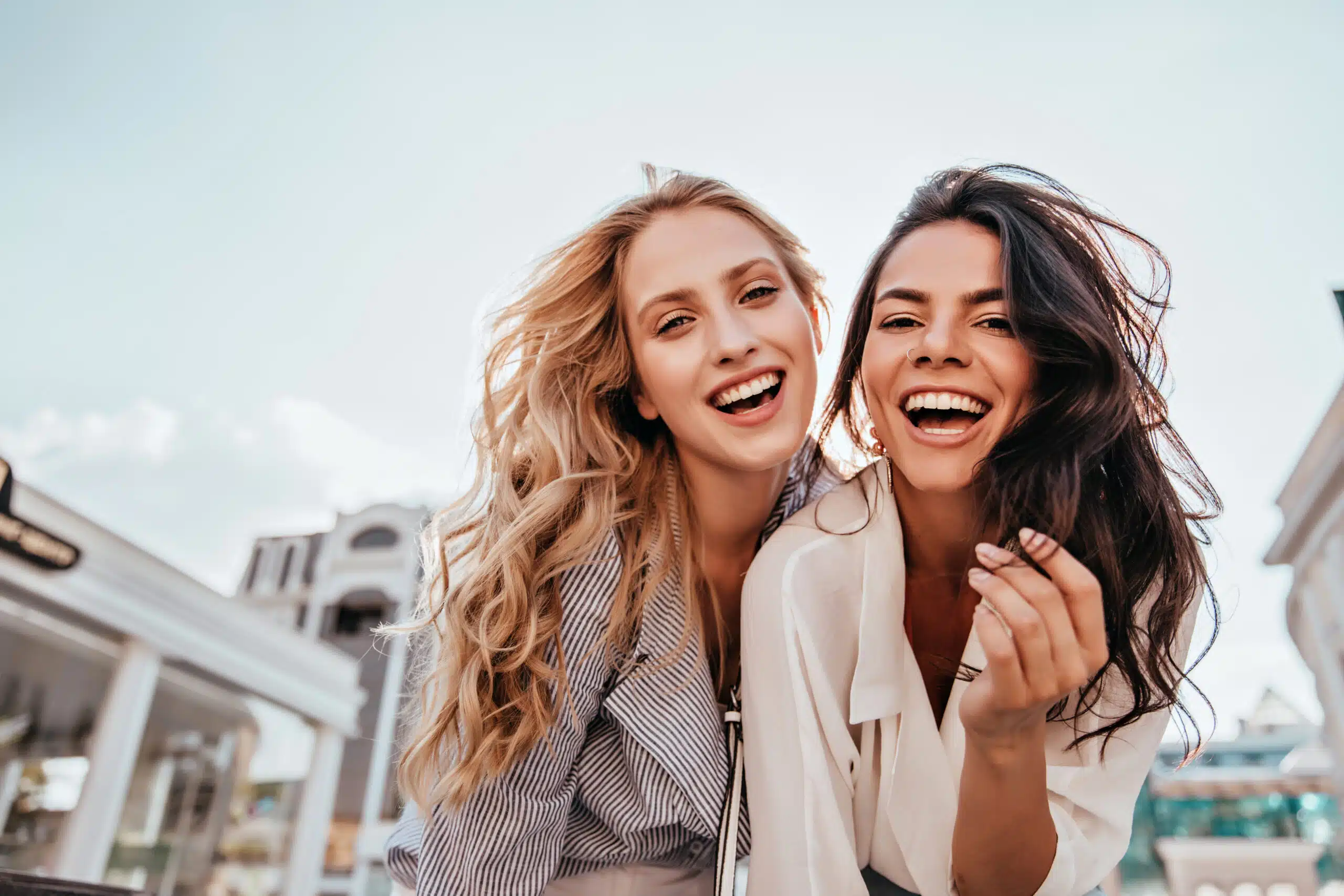 Two women smiling together while enjoying time outdoors