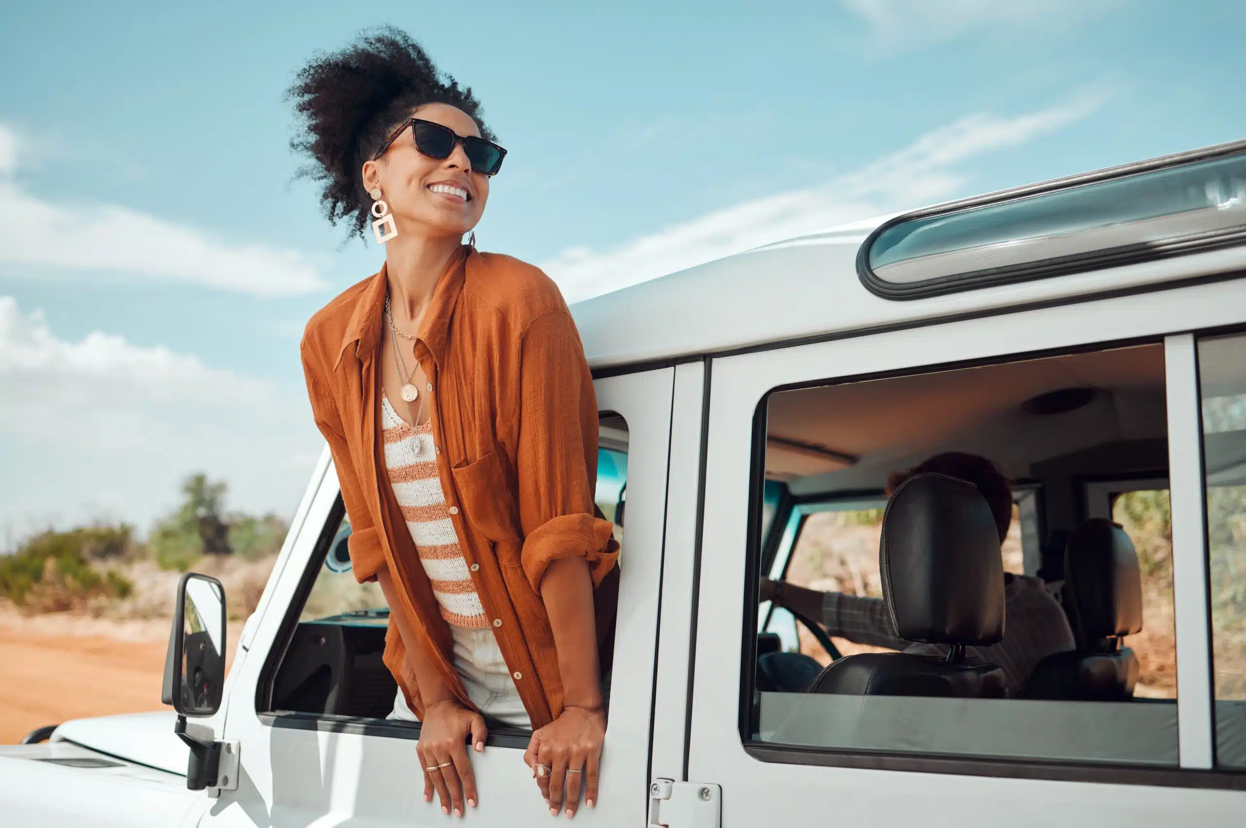 Woman smiling standing on her care while enjoying a healthy lifestyle