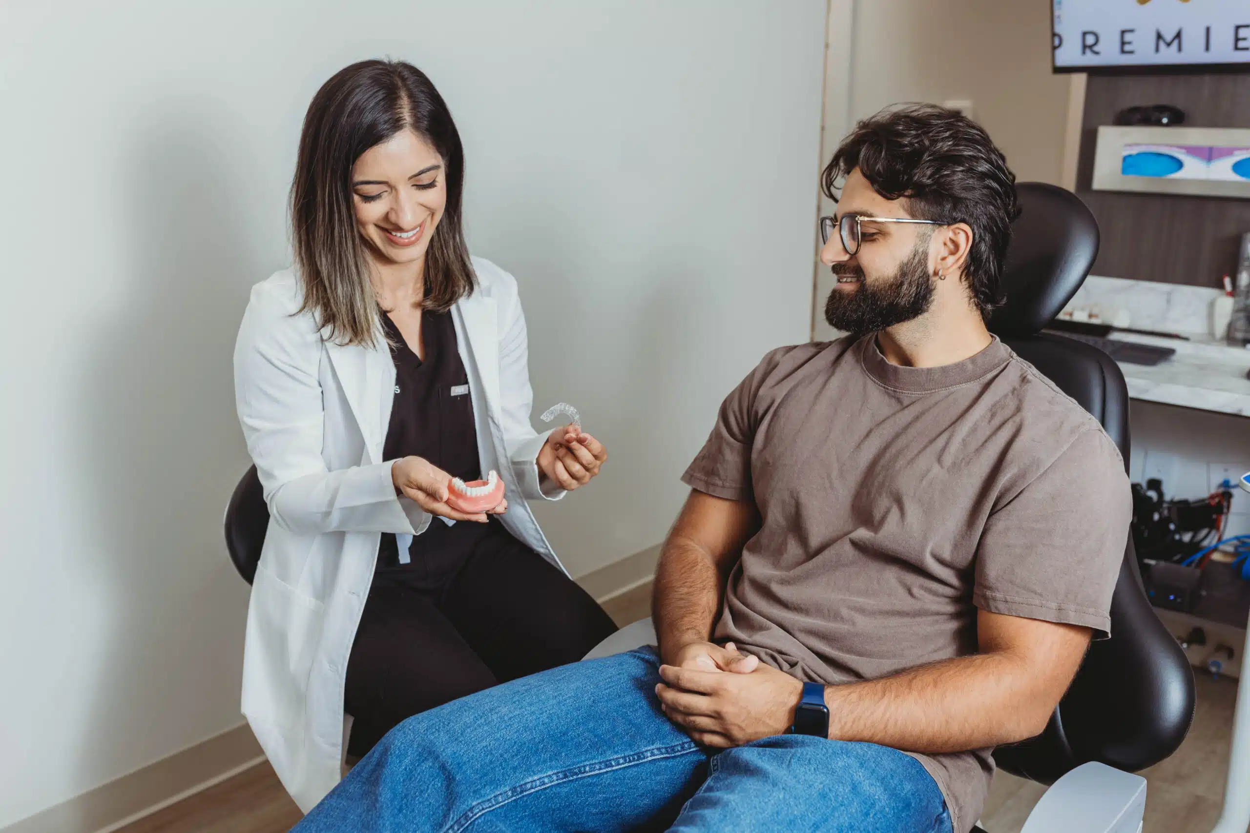 Dentist explaining Invisalign treatment to adult patient