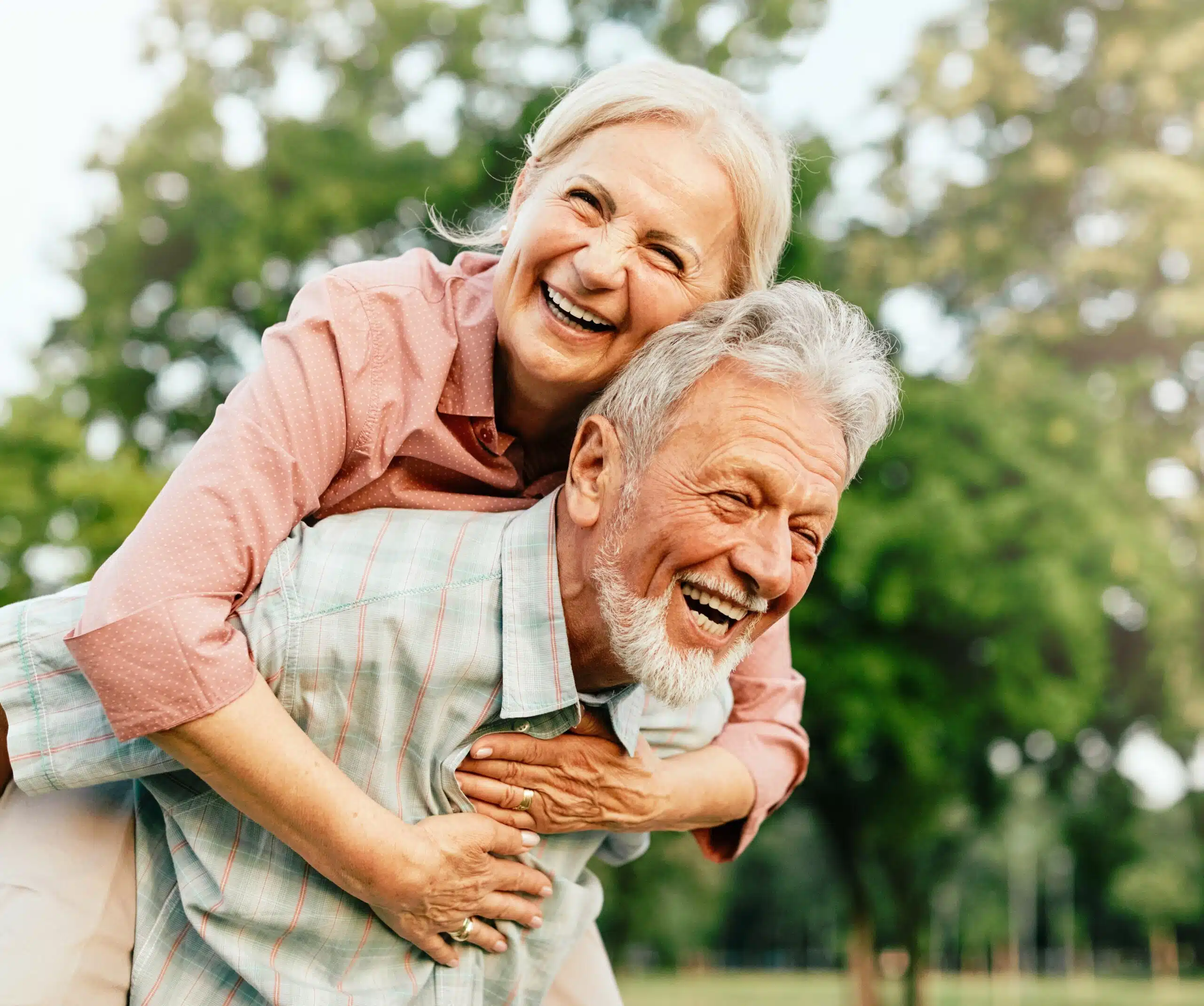 Older couple smiling together while enjoying a sunny day outdoors