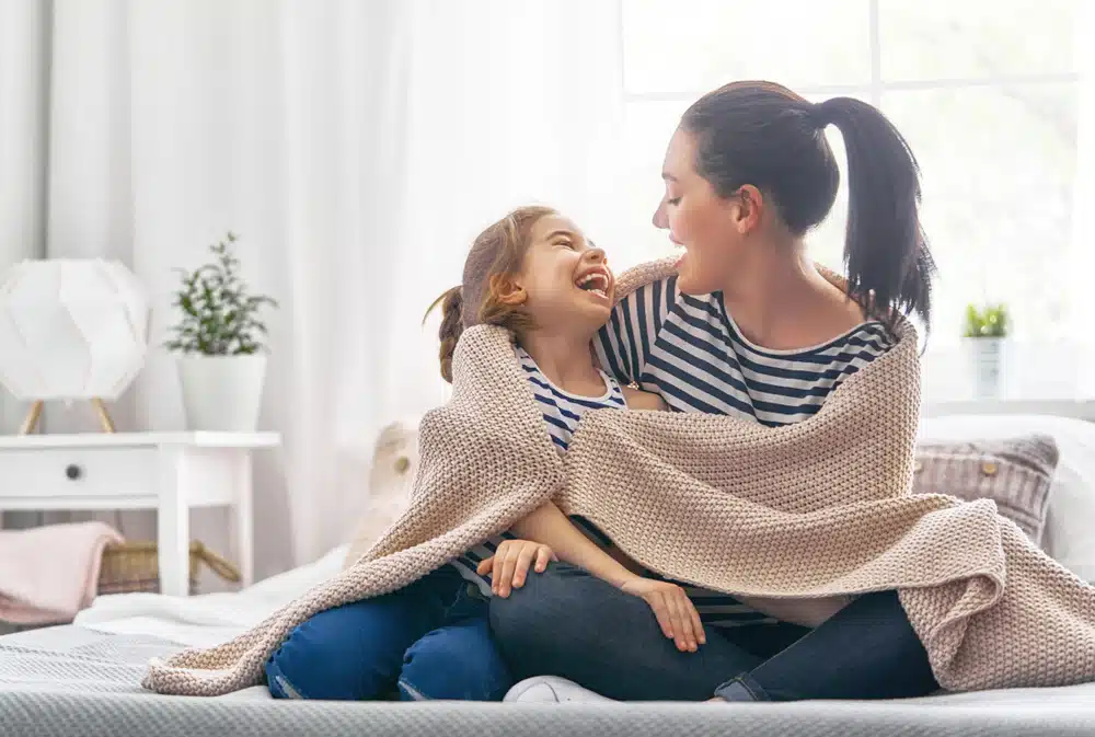 Mother and daughter smiling together at home